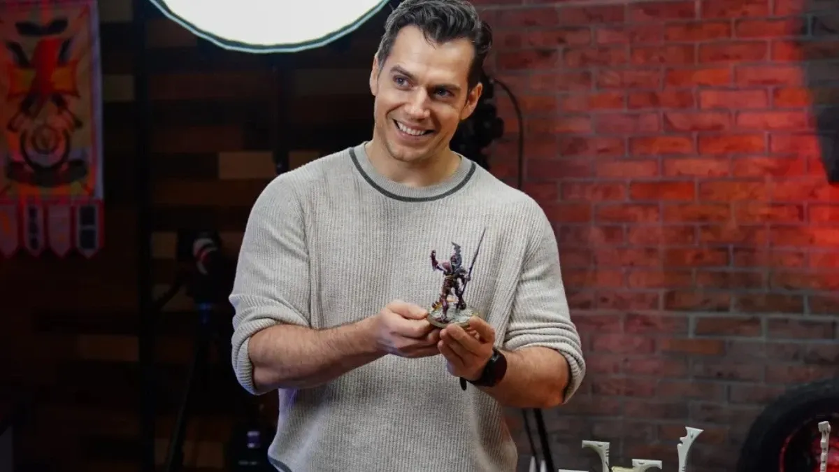 Henry Cavill showcasing a Warhammer 40k figurine 