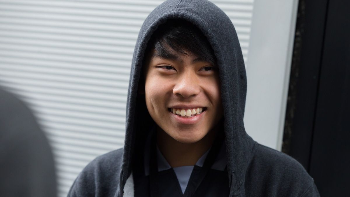 young boy smiling wearing a hoddie